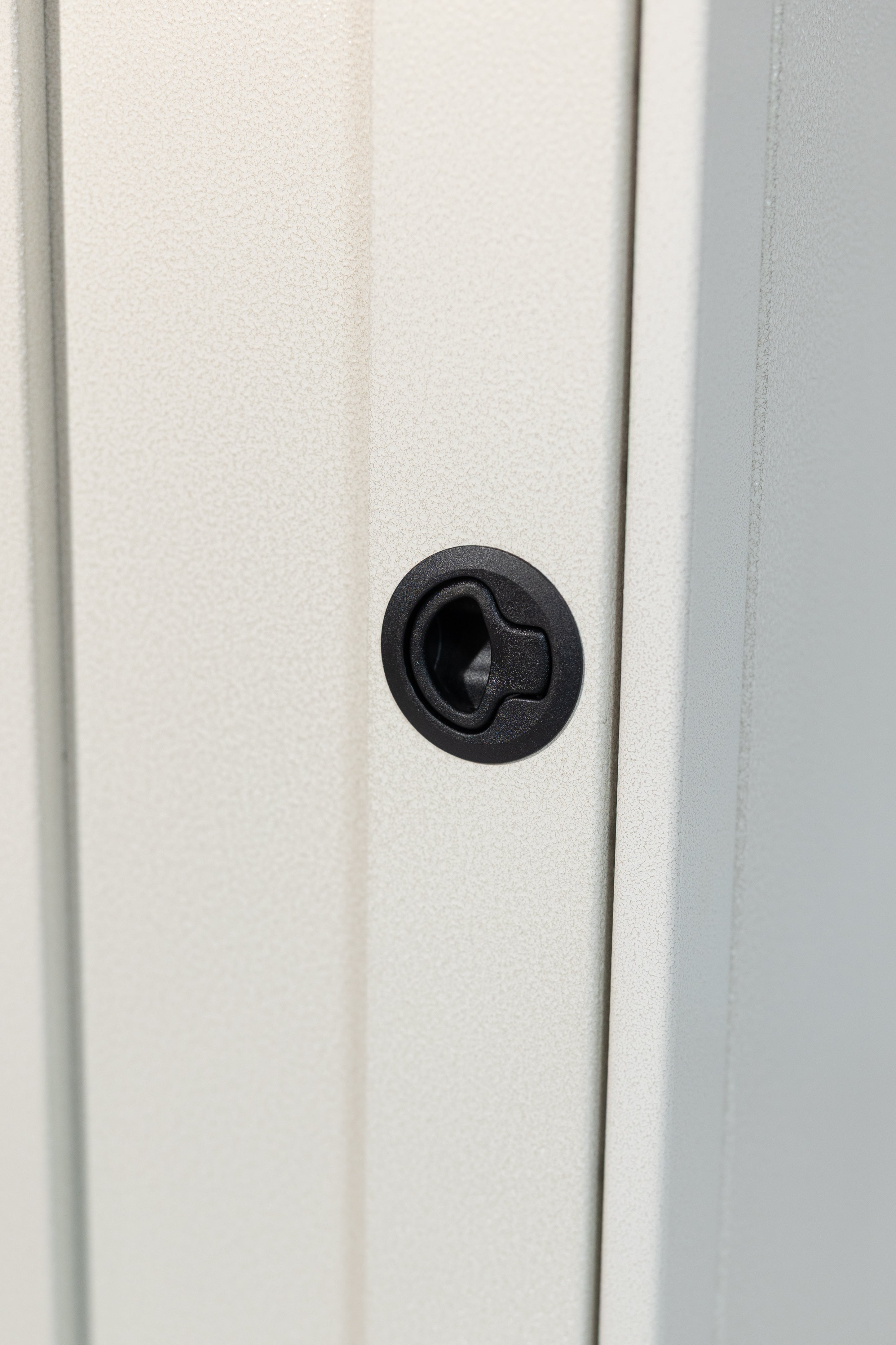 White 12-inch wide vertical aluminum upper van closet showing a single shaker-style door with flush slam latch